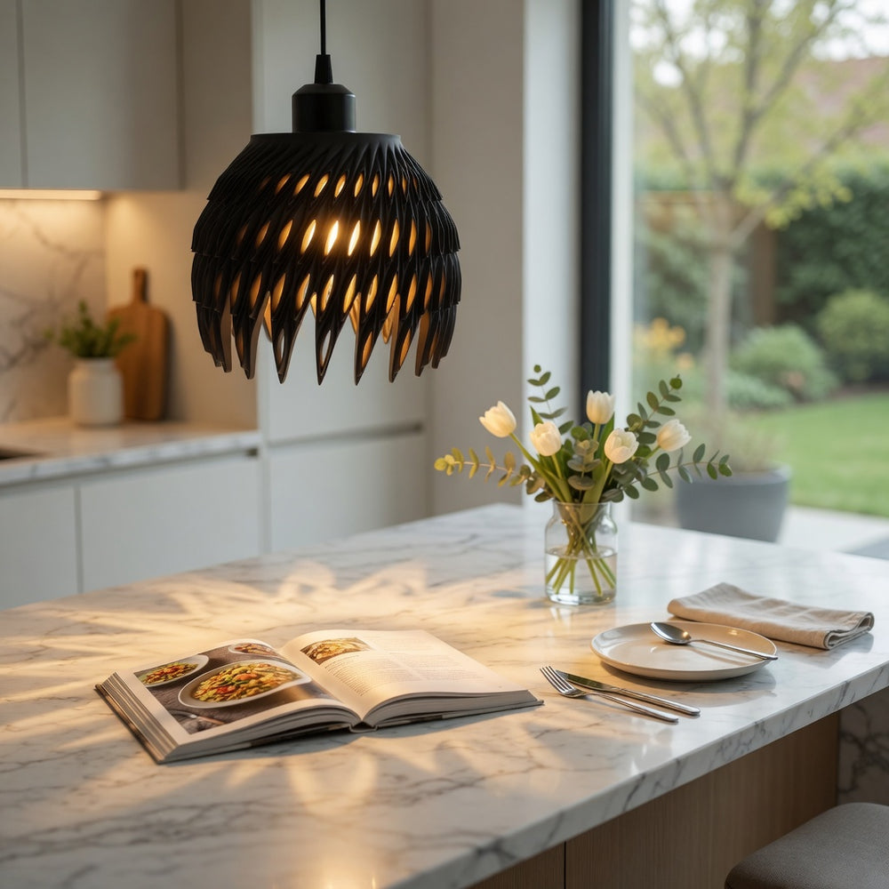 Modern kitchen with marble island, open cookbook, and decorative flowers.